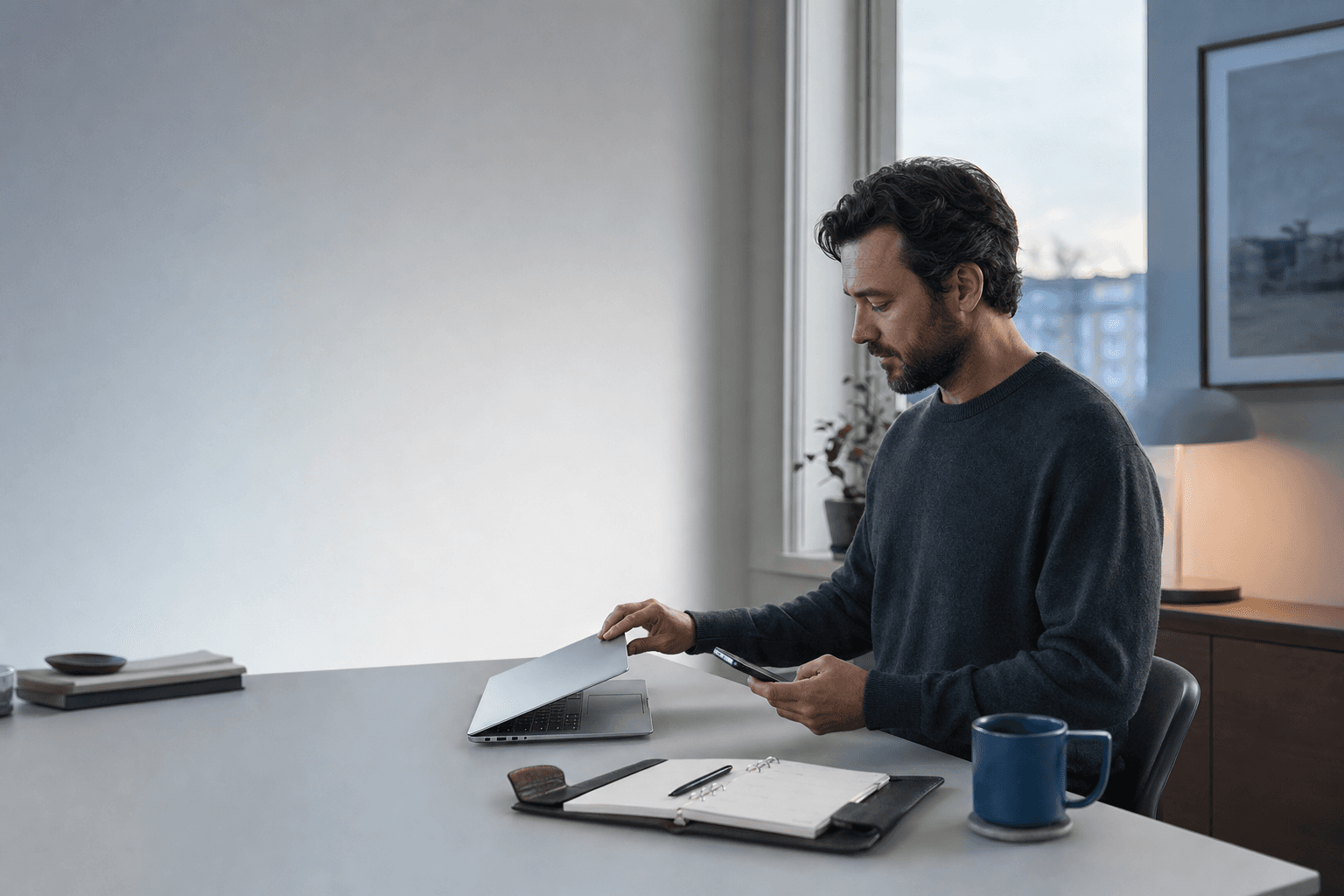 A professional closing a laptop at the end of the workday